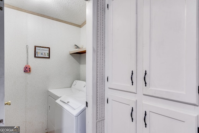 washroom featuring ornamental molding, a textured ceiling, and washer and clothes dryer