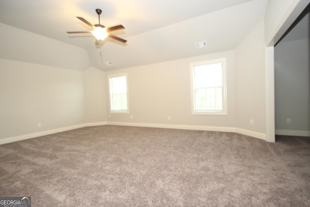 empty room featuring ceiling fan, lofted ceiling, and carpet flooring