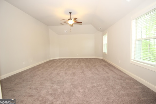 empty room with ceiling fan, lofted ceiling, and carpet flooring