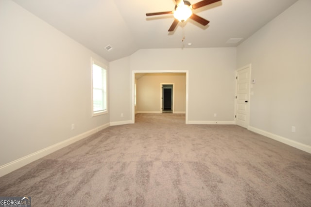 carpeted empty room featuring vaulted ceiling and ceiling fan