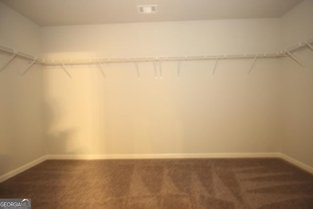 spacious closet featuring dark colored carpet