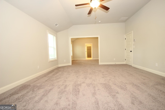 empty room with lofted ceiling, light carpet, and ceiling fan