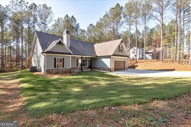 view of front of house with cooling unit, a garage, and a front yard