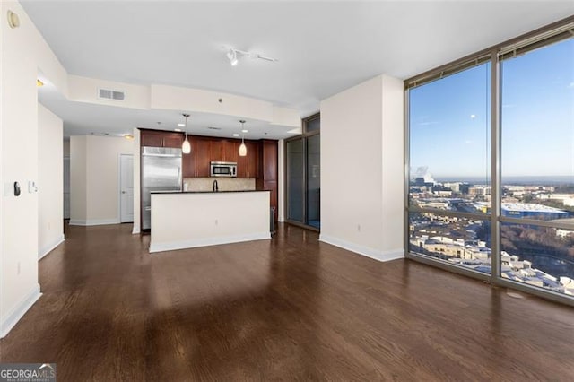 unfurnished living room featuring dark wood-type flooring and floor to ceiling windows