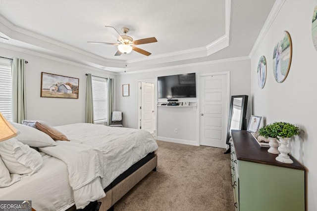 carpeted bedroom with a raised ceiling, crown molding, and ceiling fan