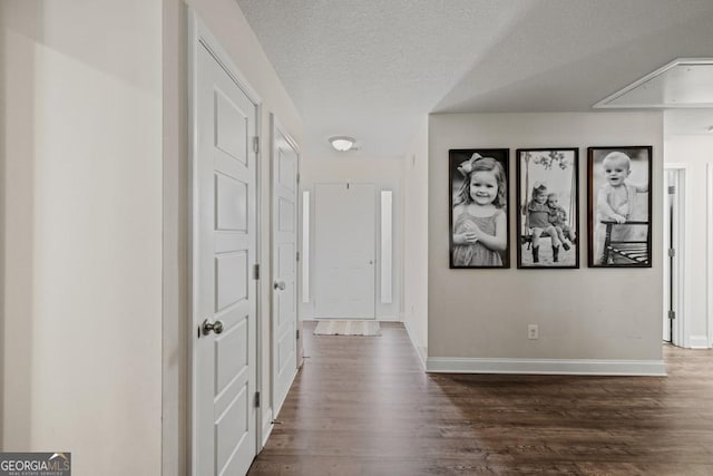 hall featuring dark wood-type flooring and a textured ceiling