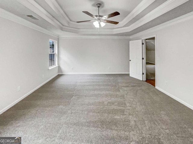 carpeted spare room with ornamental molding, a raised ceiling, and ceiling fan