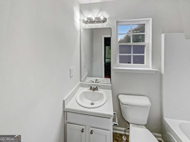 bathroom featuring vanity, a bathtub, and toilet