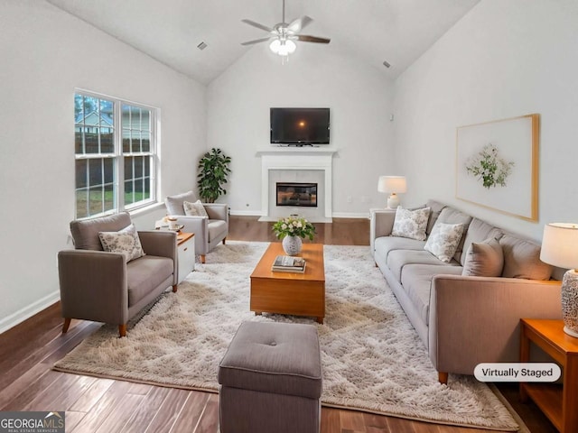 living room with ceiling fan, lofted ceiling, and hardwood / wood-style floors