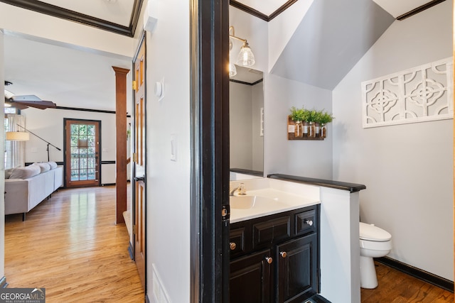 bathroom featuring hardwood / wood-style floors, crown molding, vanity, and toilet