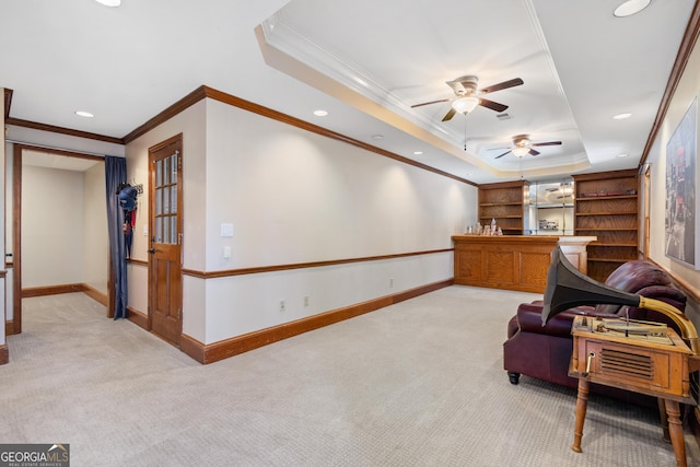 sitting room featuring light carpet, crown molding, ceiling fan, and a raised ceiling