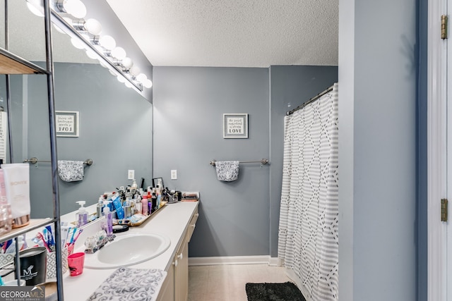 bathroom with vanity, a textured ceiling, and walk in shower