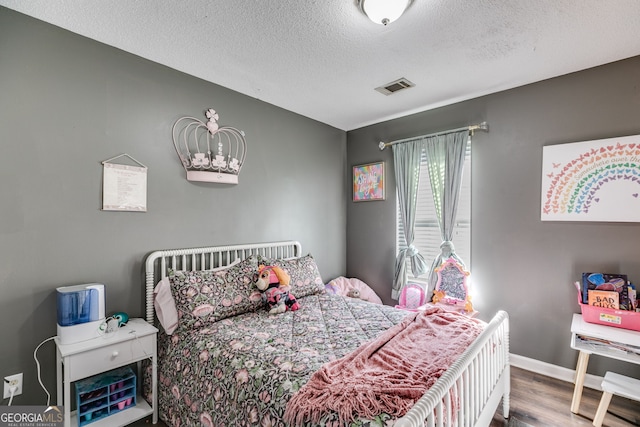 bedroom with hardwood / wood-style flooring and a textured ceiling