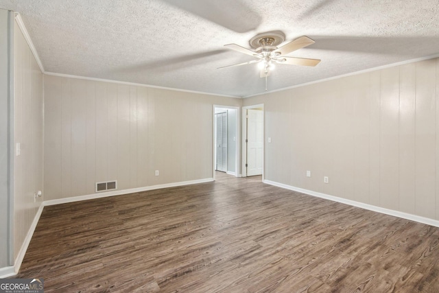 empty room featuring ceiling fan, wood finished floors, visible vents, and crown molding