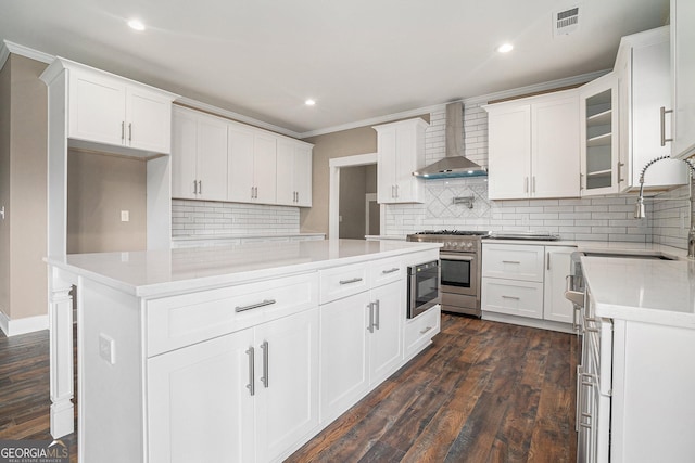 kitchen featuring sink, high end range, dark hardwood / wood-style floors, white cabinets, and wall chimney exhaust hood