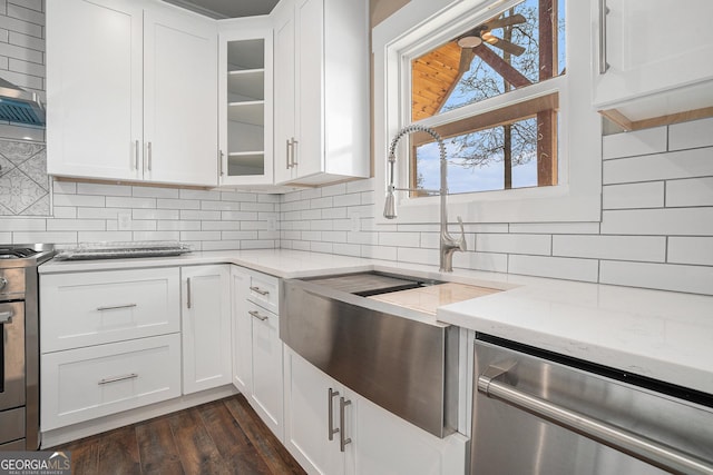 kitchen with light stone countertops, appliances with stainless steel finishes, white cabinets, and decorative backsplash