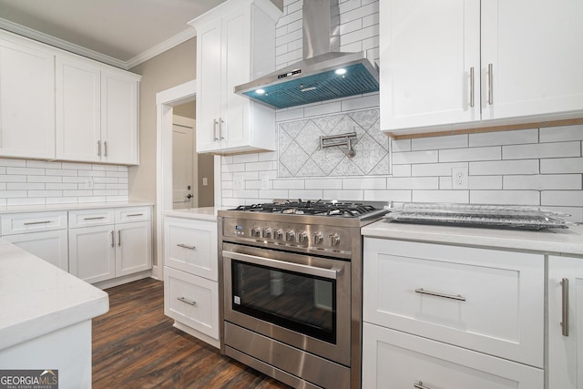 kitchen with white cabinets, crown molding, wall chimney range hood, and stainless steel range