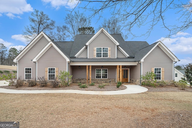 craftsman-style house featuring covered porch and a front lawn