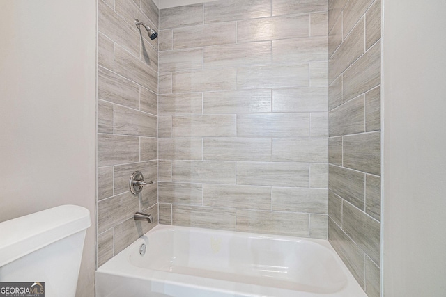 bathroom featuring tiled shower / bath and toilet