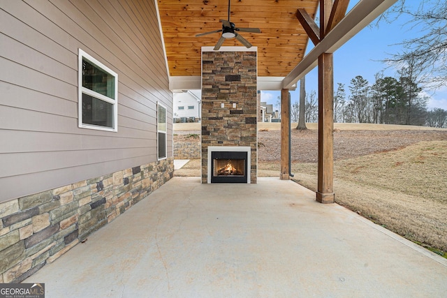 view of patio featuring ceiling fan and an outdoor stone fireplace