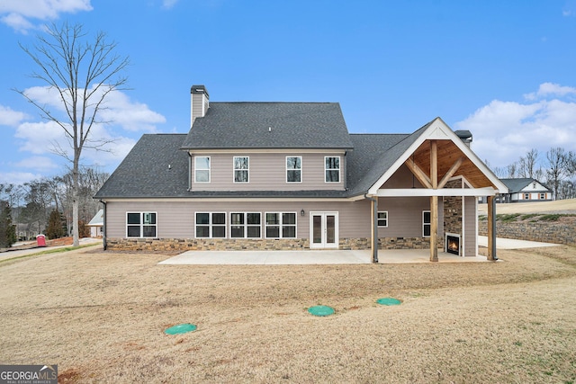 back of property featuring a fireplace and a patio