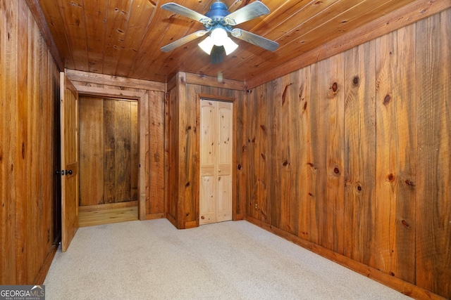 unfurnished bedroom featuring wooden ceiling, light carpet, and wood walls