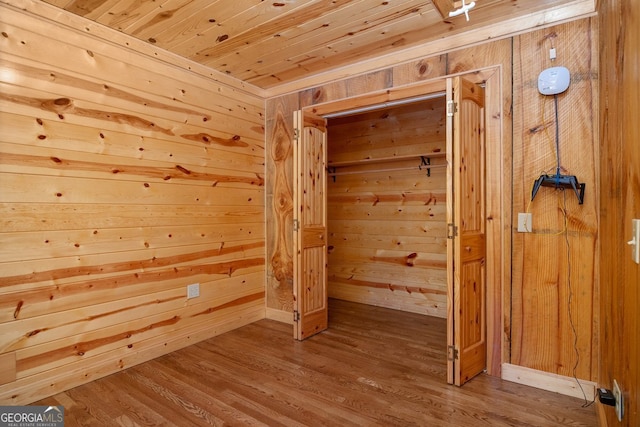 bonus room with hardwood / wood-style floors, wooden ceiling, and wooden walls