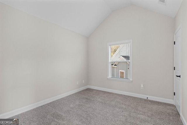 carpeted spare room featuring lofted ceiling