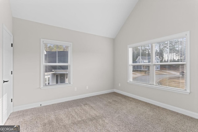 carpeted empty room with lofted ceiling