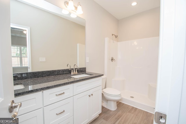 bathroom featuring vanity, hardwood / wood-style floors, toilet, and walk in shower