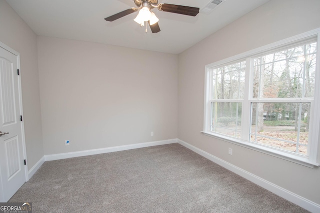 carpeted spare room featuring ceiling fan