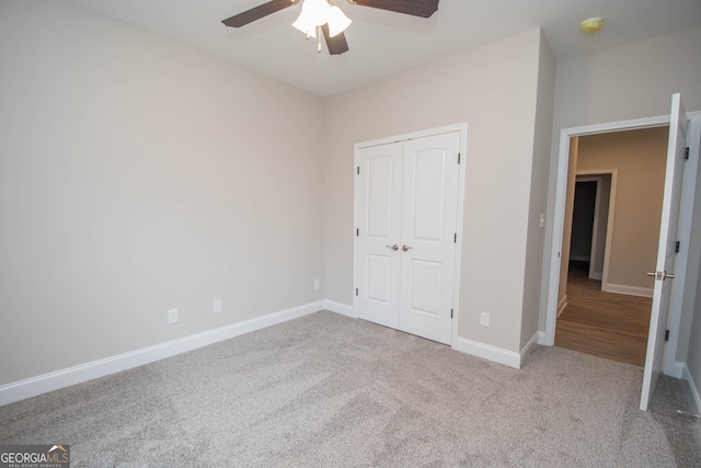 unfurnished bedroom featuring ceiling fan, light colored carpet, and a closet