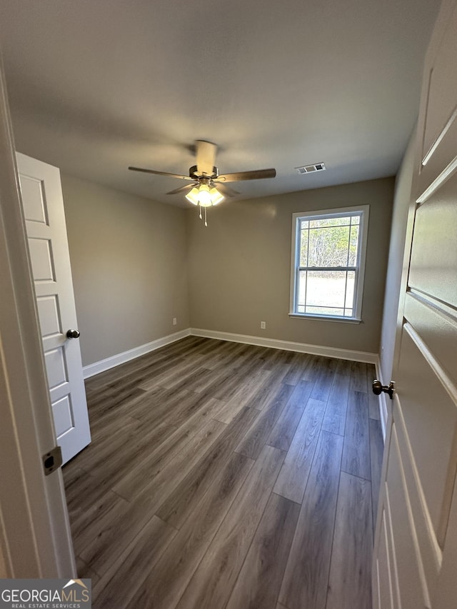 unfurnished bedroom with visible vents, baseboards, dark wood-type flooring, and ceiling fan