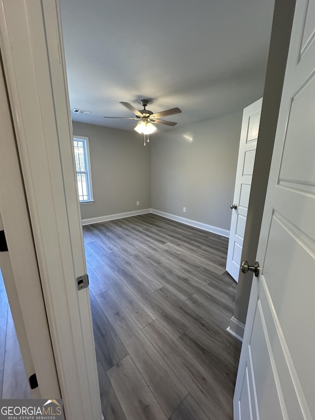 empty room featuring ceiling fan and dark hardwood / wood-style floors