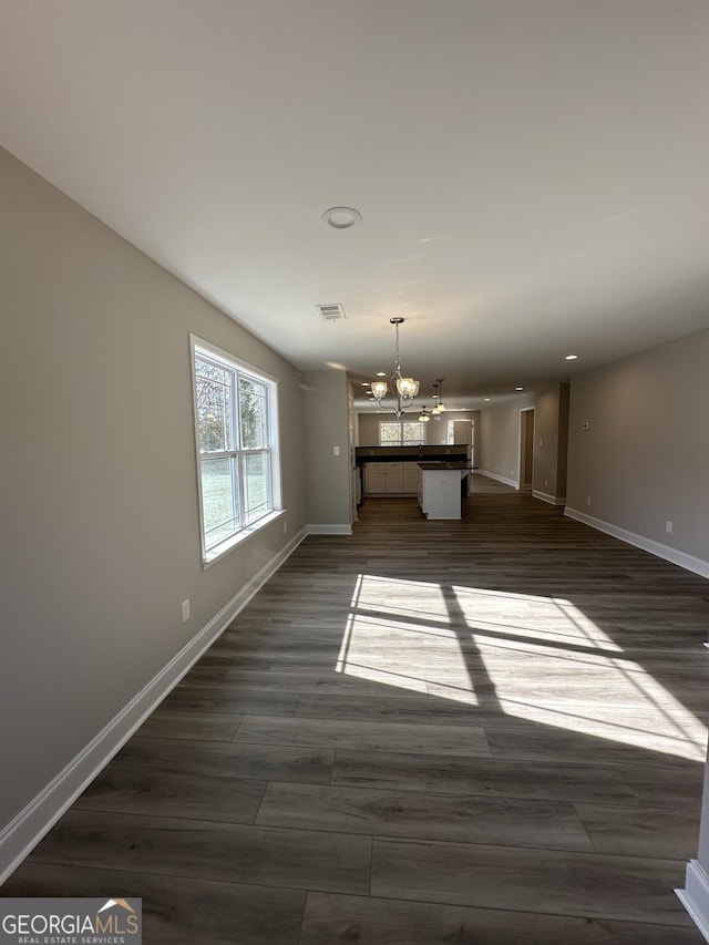 interior space featuring an inviting chandelier and dark wood-type flooring