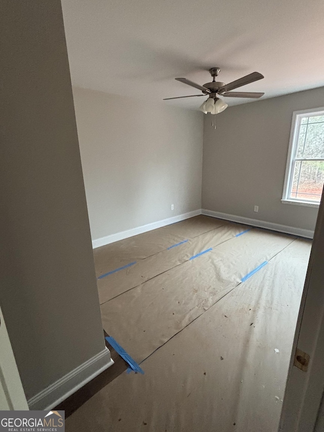 empty room featuring baseboards and ceiling fan