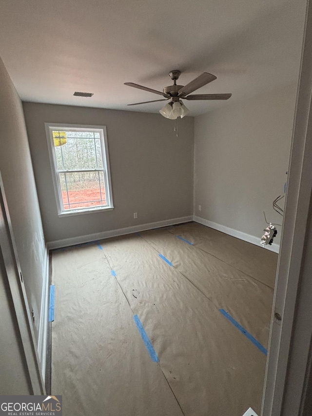 unfurnished room featuring visible vents, baseboards, and ceiling fan