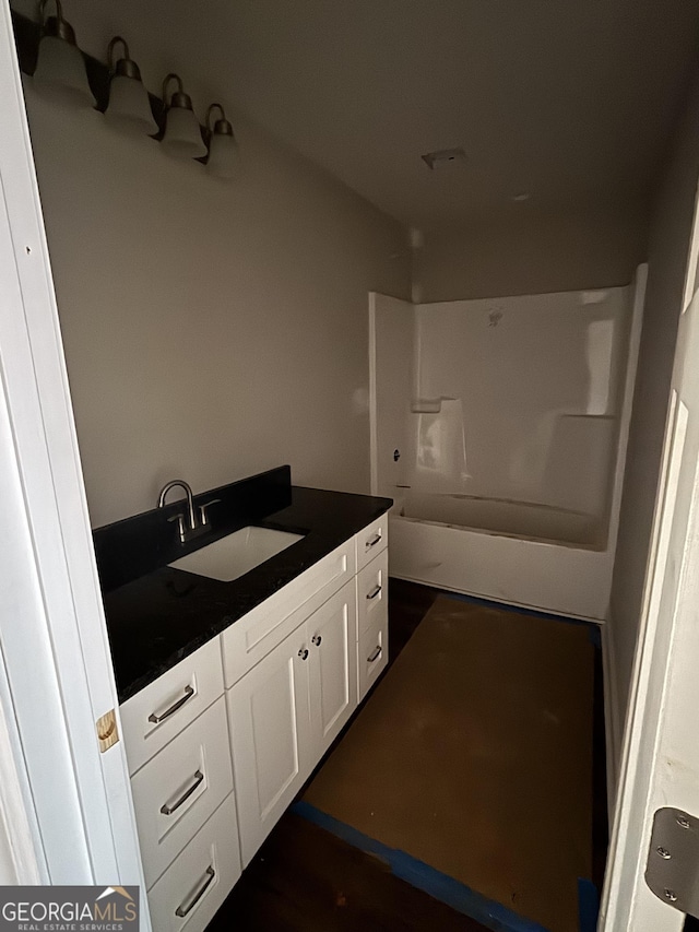 bathroom featuring vanity and  shower combination