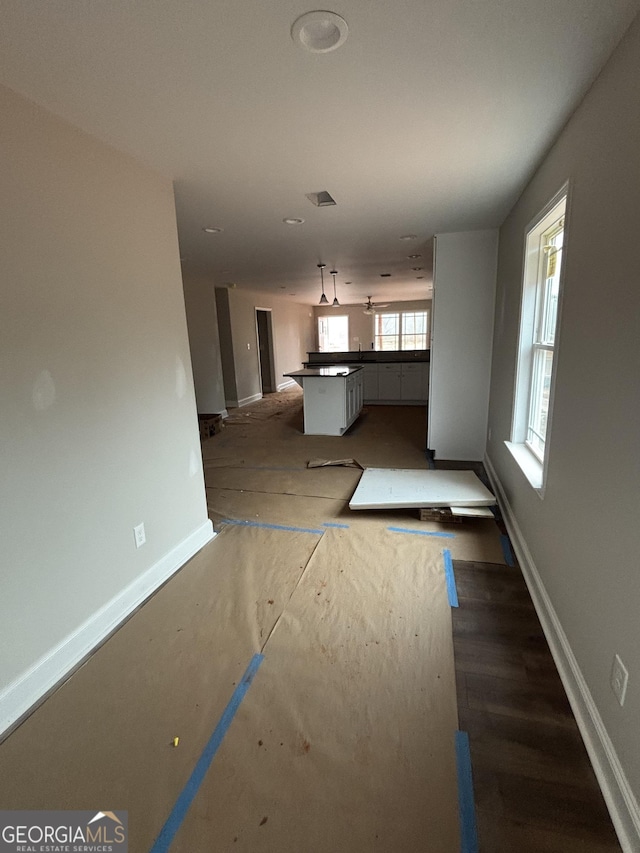 unfurnished living room featuring visible vents and baseboards