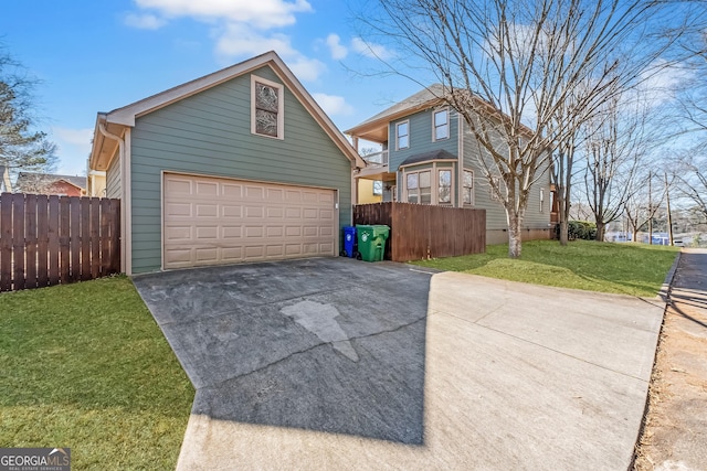 exterior space featuring a garage, a yard, fence, and driveway