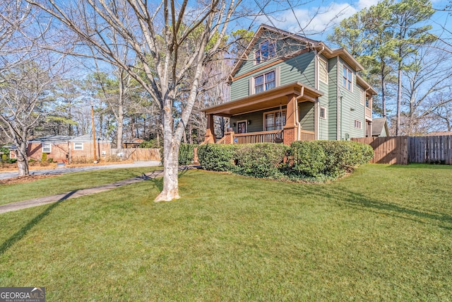 view of front facade featuring a front yard, a porch, and fence