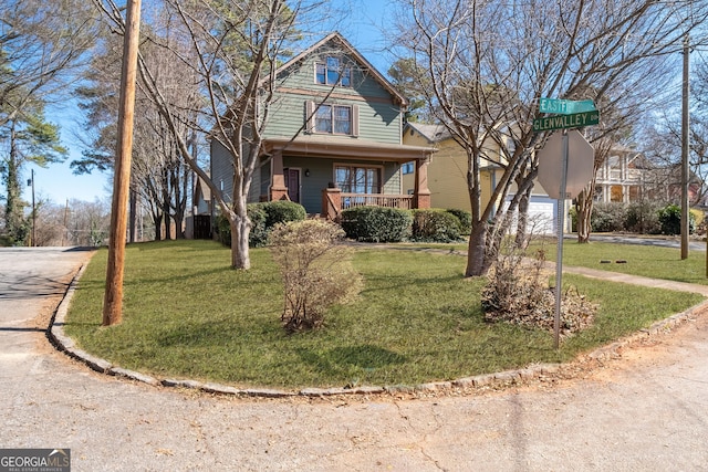 view of front facade with a front yard, covered porch, and driveway