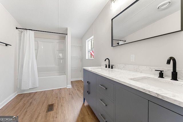 bathroom with vaulted ceiling, vanity, hardwood / wood-style floors, and shower / bath combo