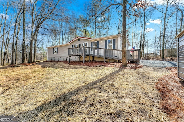 manufactured / mobile home with a wooden deck and a front yard