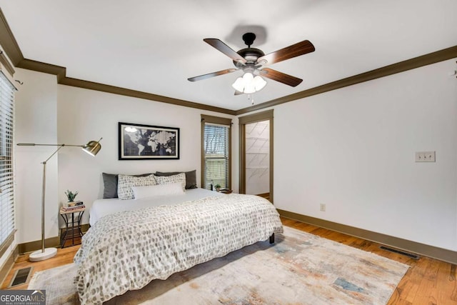 bedroom featuring hardwood / wood-style floors, ornamental molding, and ceiling fan