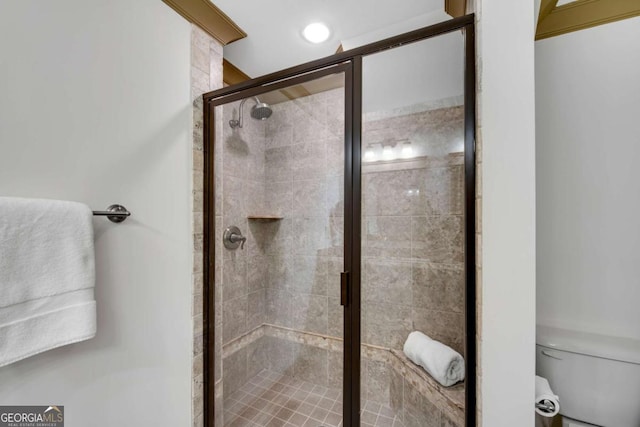 bathroom with a shower with door and toilet