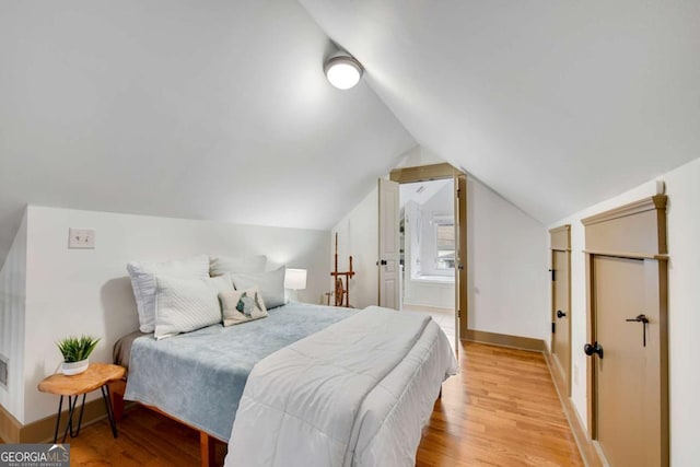 bedroom featuring vaulted ceiling and light hardwood / wood-style floors