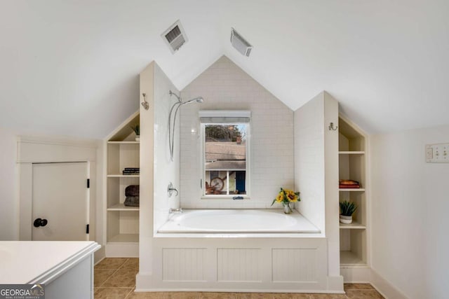 bathroom with built in shelves, lofted ceiling, plus walk in shower, and tile patterned flooring