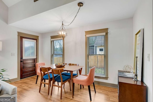 dining area with a notable chandelier and light hardwood / wood-style flooring