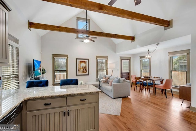 living room with beamed ceiling, ceiling fan with notable chandelier, high vaulted ceiling, and light hardwood / wood-style flooring